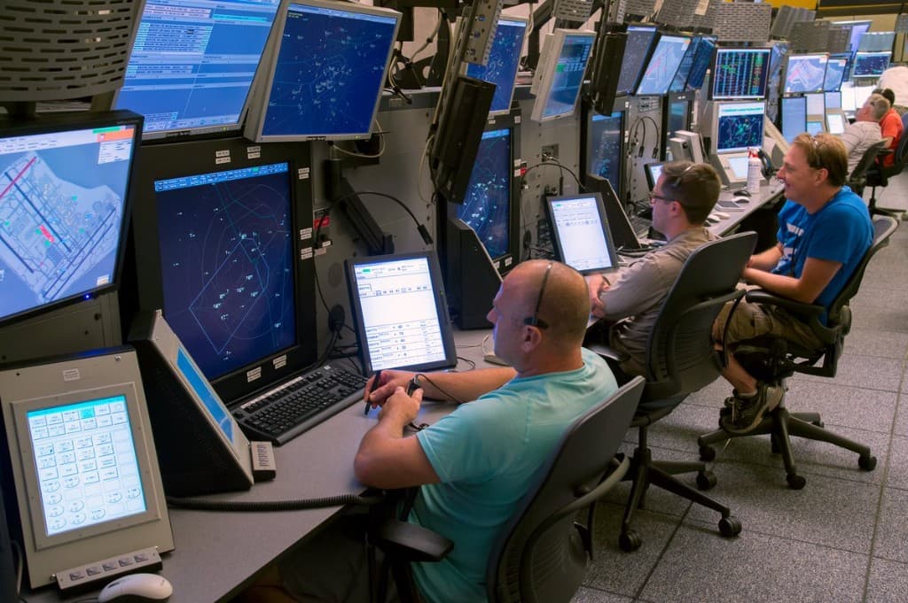 Air traffic controllers working at radar consoles in an area control centre